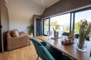 a living room with a wooden table and a couch at SeaBeds - Luxury Lookouts with Hot Tubs in Glencoe