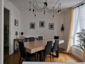 a dining room with a wooden table and chairs at Chez Camille in Reims