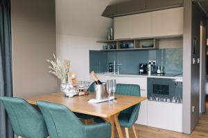 a kitchen with a table, chairs, and a refrigerator at SeaBeds - Luxury Lookouts with Hot Tubs in Fort William