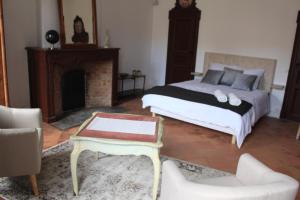 1 dormitorio con 1 cama con chimenea y mesa en CHIC ANDREOSSY-COSY-AUTHENTIQUE-WI-Fi-Vélo, en Castelnaudary