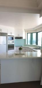 a kitchen with white cabinets and a counter top at Crown Towers Resort Private Apartments in Gold Coast