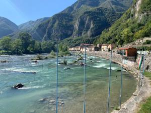 a river in the mountains with people swimming in it at Ca'Noa in Valstagna
