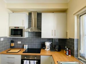 a kitchen with white cabinets and a counter top at Heart of Hastings Historic Old Town in Hastings