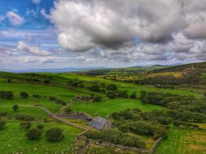 an aerial view of an old farm in a green field at Gellibant Cottage in Llanbedr