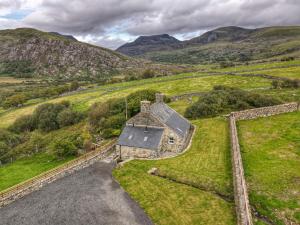 an aerial view of an old house in a green field at Gellibant Cottage in Llanbedr