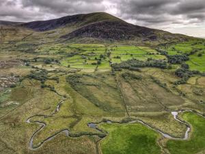 an aerial view of a field with a mountain at Gellibant Cottage in Llanbedr