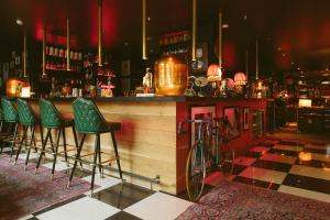 a bar with green stools and a bike parked at it at Aethos Milan in Milan