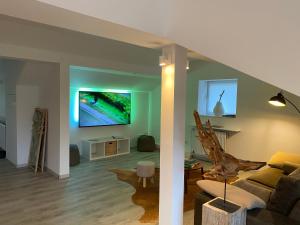 een woonkamer met een bank en een tv bij Natur Panorama Suiten am Rursee in Heimbach