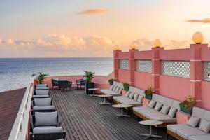 a row of wooden benches sitting on top of a beach at Terceira Mar Hotel in Angra do Heroísmo