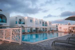 a hotel with a swimming pool in front of a building at Kaos Hotel Apartments in Ayia Napa