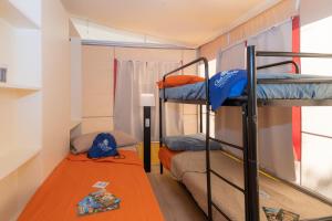 a dorm room with two bunk beds and a table at Marina Family Village in Punta Marina