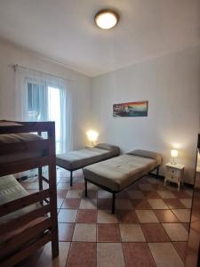 a room with two beds and a table and a window at Residence La Lanterna in Genova