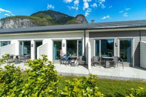 a person sitting on the patio of a house at Valldal Fjordhotell - by Classic Norway Hotels in Valldal