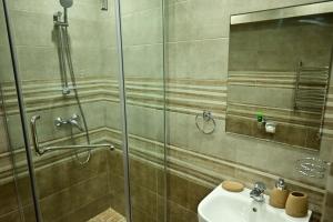 een badkamer met een douche en een wastafel bij Гостиница Asgard in Boedjonnovsk