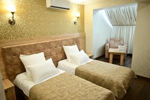 een hotelkamer met 2 bedden en een stoel bij Гостиница Asgard in Boedjonnovsk