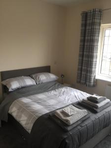 a bed with towels on it in a bedroom at The Woodhouse Inn in Worksop