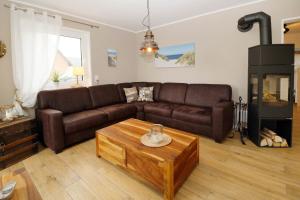 a living room with a brown couch and a fireplace at Ferienhaus Hinnerk_SCHL in Ostseebad Karlshagen