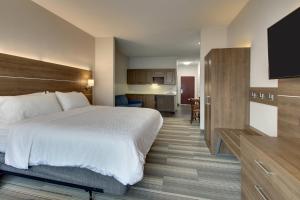 a hotel room with a bed and a kitchen at Holiday Inn Express & Suites Laurel, an IHG Hotel in Laurel