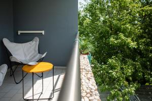 balcone con sedia, tavolo e alberi di Hotel Savoy a Grado