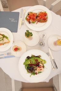 una mesa blanca con platos de comida. en Hotel Savoy, en Grado