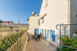 a balcony of a white building with chairs on it at Marine - Maison et jardin - Grande Plage à 150 m in Barneville-Carteret