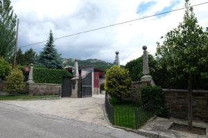 ein Haus mit einem schwarzen Zaun und einem Hof in der Unterkunft El Barranco de Miraflores in Miraflores de la Sierra