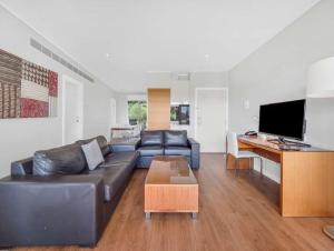 a living room with a black leather couch and a table at Stunning resort apartment in San Remo in San Remo