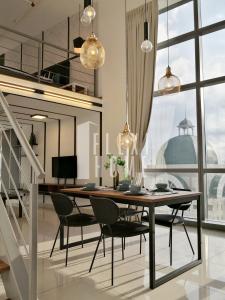 ein Esszimmer mit einem Tisch und Stühlen sowie einem großen Fenster in der Unterkunft Pinnacle PJ, Romantic City View, 1-4 Guests Designed Duplex Home by Flexihome-MY in Petaling Jaya