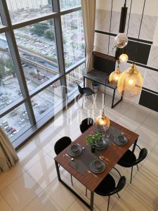 - une table à manger et des chaises dans une pièce dotée de grandes fenêtres dans l'établissement Pinnacle PJ, Romantic City View, 1-4 Guests Designed Duplex Home by Flexihome-MY, à Petaling Jaya