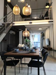 a dining room with a wooden table and chairs at Pinnacle PJ, Romantic City View, 1-4 Guests Designed Duplex Home by Flexihome-MY in Petaling Jaya