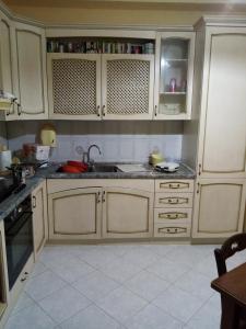 una cucina con armadi bianchi e lavandino di CASA 92100 appartamento in centro ad Agrigento. a Agrigento