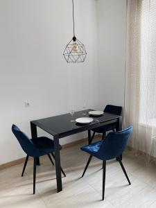 uma mesa de jantar preta com 2 cadeiras azuis em VIP Apartment Rovno & Новобудова ЖК Театральний Центр em Rivne