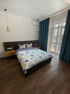 a bedroom with a bed and a window with blue curtains at VIP Apartment Rovno & Новобудова ЖК Театральний Центр in Rivne