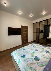 1 dormitorio con 1 cama y TV de pantalla plana en VIP Apartment Rovno & Новобудова ЖК Театральний Центр, en Rivne