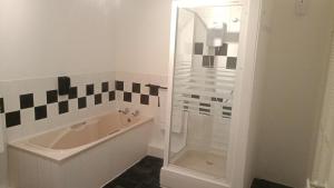 a bathroom with a bath tub and a shower at The Old Surgery in Blaenau-Ffestiniog +18 photos