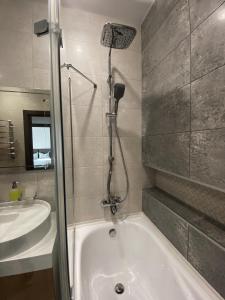 uma casa de banho com um chuveiro, uma banheira e um lavatório. em VIP Apartment Rovno & Новобудова ЖК Театральний Центр em Rivne