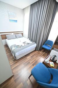 a bedroom with a bed and two blue chairs at Safir Gold Hotel in Istanbul