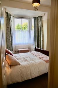 a bedroom with a bed in front of a window at Mostyn Villa in Llandudno
