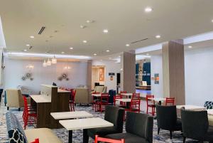 a restaurant with tables and chairs and a bar at La Quinta Inn & Suites by Wyndham - Red Oak TX IH-35E in Red Oak