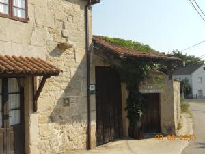 an old stone building with a door and ivy at Casa de Campos in Silleda