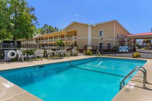 a swimming pool with chairs and a building at Econo Lodge in Saint George