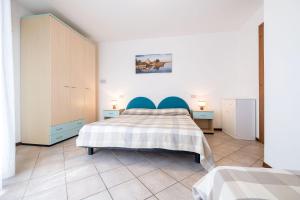 1 dormitorio con 1 cama con cabecero azul en Appartamenti Lignano Sabbiadoro - Villa Ammiraglia en Lignano Sabbiadoro