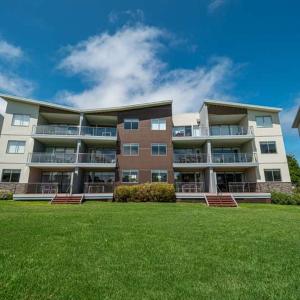 a large apartment building with a lawn in front of it at Stunning resort apartment in San Remo in San Remo