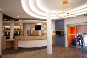 a lobby with a large circular ceiling at Comfort Hotel Clermont Saint Jacques in Clermont-Ferrand