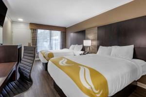 una camera d'albergo con due letti e una scrivania di Quality Inn & Suites a Pawleys Island Altre 21 foto