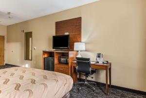 Habitación de hotel con cama, escritorio y TV. en Quality Inn & Suites Hendersonville - Flat Rock, en Flat Rock
