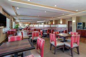 een restaurant met houten tafels en rode stoelen bij Comfort Suites Biloxi/Ocean Springs in Biloxi