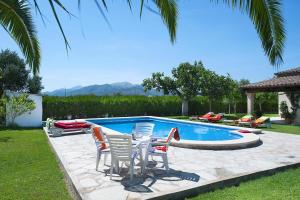 a group of chairs sitting around a swimming pool at Villa BURGUES in Alcudia