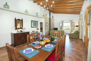 a dining room and living room with a table and chairs at Villa BURGUES in Alcudia