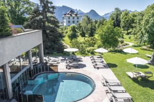 ein Resort mit einem Pool und Stühlen sowie einem Gebäude in der Unterkunft Hotel Bemelmans-Post in Klobenstein